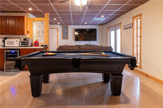 playroom with billiards, light hardwood / wood-style flooring, electric panel, beverage cooler, and a drop ceiling