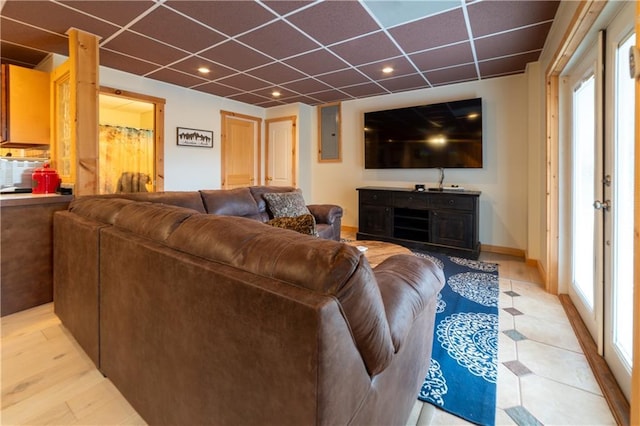 living room with a paneled ceiling, electric panel, and light wood-type flooring