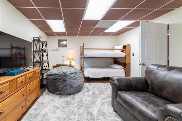 bedroom featuring a drop ceiling and carpet flooring