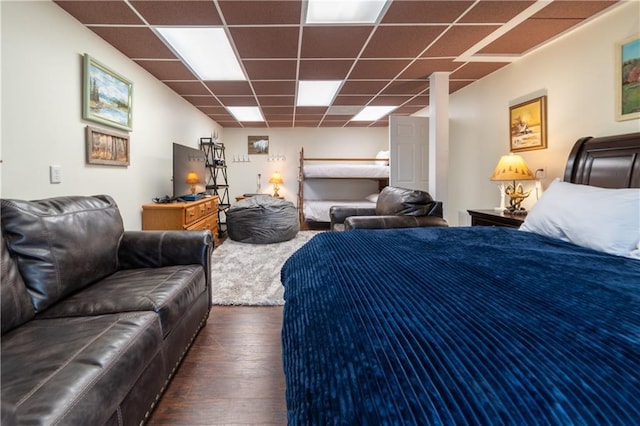 bedroom with dark hardwood / wood-style floors and a drop ceiling