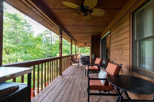 wooden deck featuring a hot tub and ceiling fan