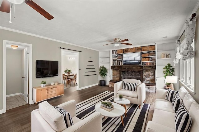 living room with built in shelves, ornamental molding, dark hardwood / wood-style floors, and ceiling fan