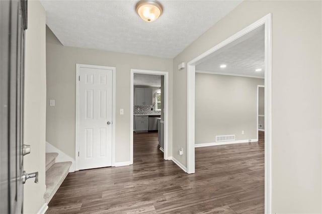 spare room featuring dark wood-type flooring and a textured ceiling