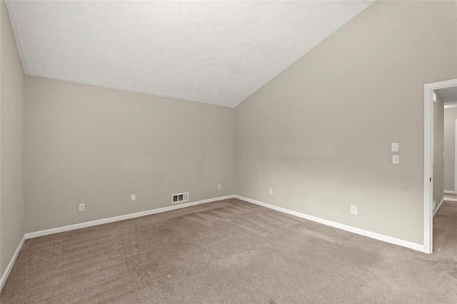 empty room with lofted ceiling and carpet flooring