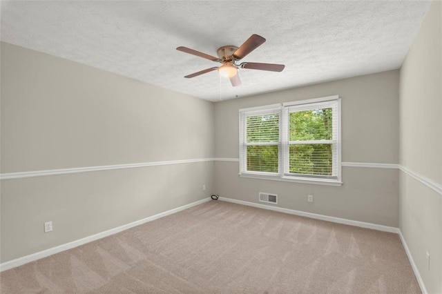 carpeted empty room with ceiling fan and a textured ceiling