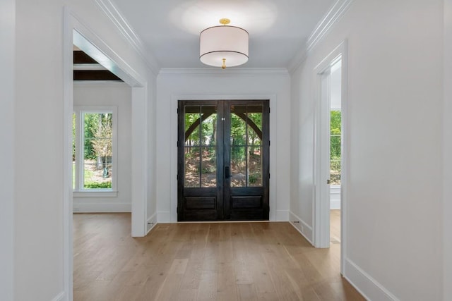 entrance foyer featuring light hardwood / wood-style flooring, ornamental molding, and french doors