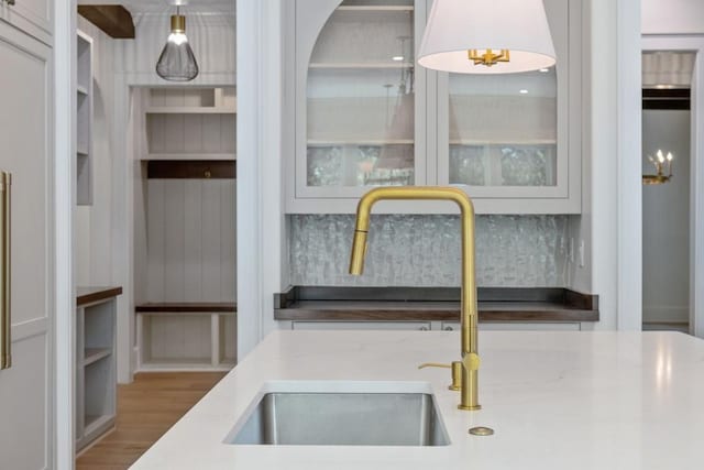 interior space with tasteful backsplash, hardwood / wood-style floors, and sink