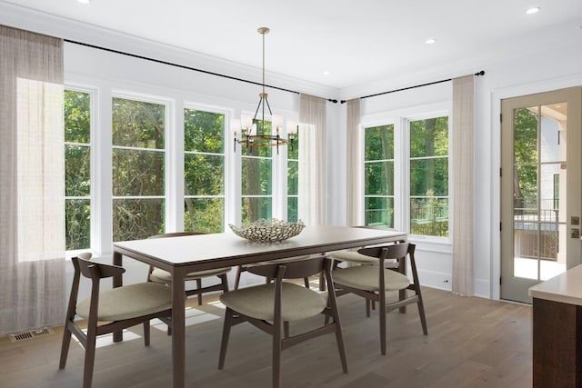 dining space with plenty of natural light, a chandelier, and hardwood / wood-style flooring