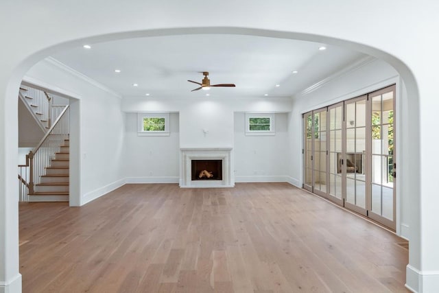 unfurnished living room featuring ornamental molding, light hardwood / wood-style flooring, and ceiling fan