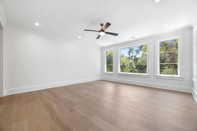 empty room with ceiling fan, ornamental molding, and light hardwood / wood-style floors