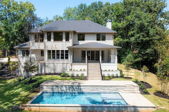 back of house featuring a fenced in pool and a lawn