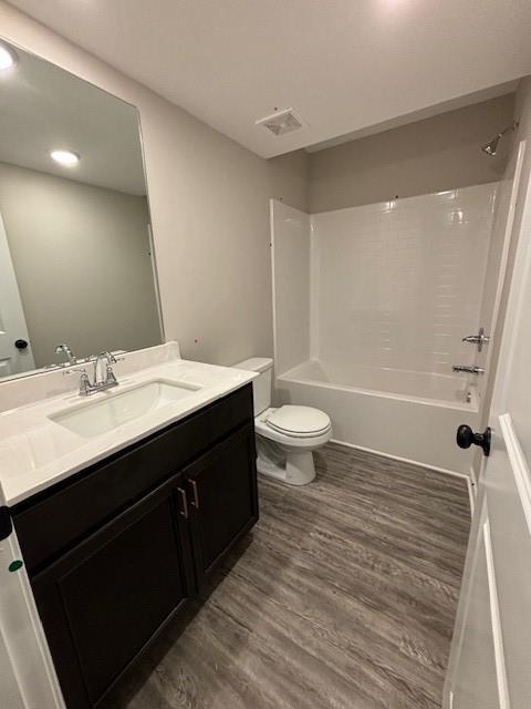 bathroom featuring a shower with shower door, hardwood / wood-style flooring, and vanity