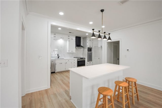 3649 Peachtree Rd NE Unit 305, Atlanta, GA 30319 - kitchen with wall chimney exhaust hood, stainless steel appliances, crown molding, white cabinetry, and a sink