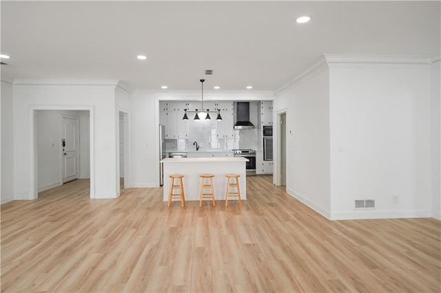 3649 Peachtree Rd NE Unit 305, Atlanta, GA 30319 - kitchen with wall chimney range hood, stainless steel range oven, crown molding, a breakfast bar, and recessed lighting