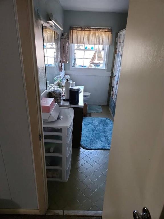 full bathroom with toilet and a shower with curtain