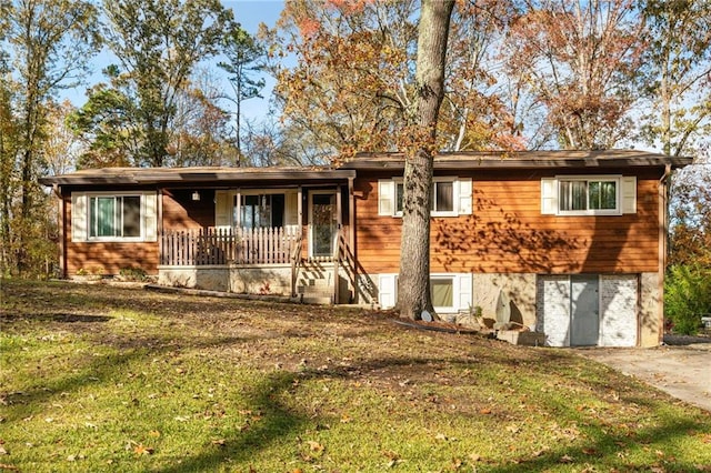 ranch-style house featuring covered porch and a front yard