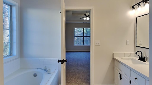 bathroom featuring ceiling fan, a tub, and vanity