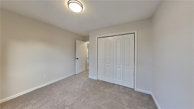 unfurnished bedroom with light colored carpet and a closet