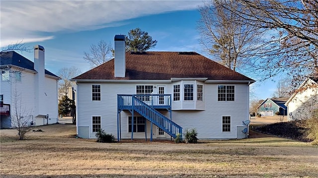 rear view of property with a yard and a wooden deck