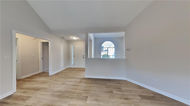 empty room featuring lofted ceiling and light hardwood / wood-style flooring