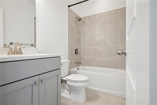 full bathroom featuring vanity, tiled shower / bath, toilet, and tile patterned flooring