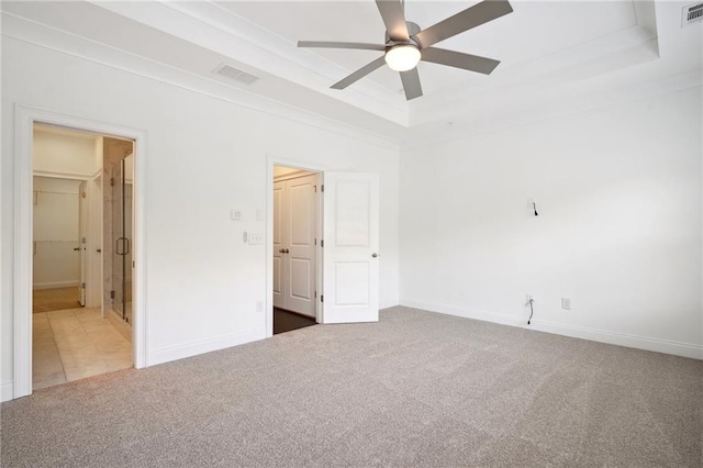 unfurnished bedroom featuring carpet, a tray ceiling, and ceiling fan