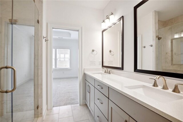 bathroom with vanity, a shower with shower door, and tile patterned floors