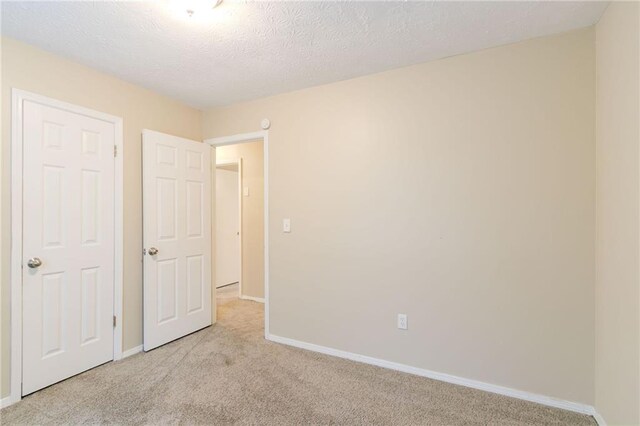 1841 Northwick Pl, Lithonia, GA 30058 - unfurnished bedroom featuring light colored carpet and a textured ceiling