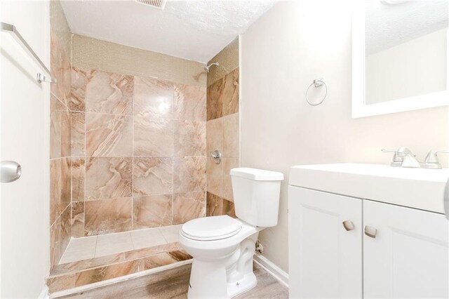 1841 Northwick Pl, Lithonia, GA 30058 - bathroom featuring vanity, toilet, tiled shower, and a textured ceiling