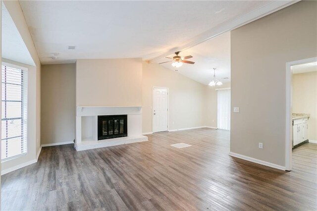 1841 Northwick Pl, Lithonia, GA 30058 - unfurnished living room featuring vaulted ceiling with beams, a brick fireplace, a healthy amount of sunlight, and hardwood / wood-style flooring