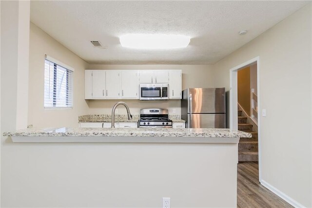 1841 Northwick Pl, Lithonia, GA 30058 - kitchen with kitchen peninsula, appliances with stainless steel finishes, white cabinetry, and sink
