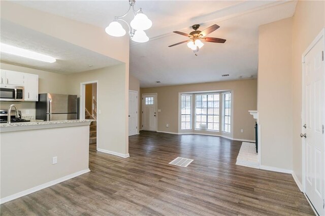 1841 Northwick Pl, Lithonia, GA 30058 - unfurnished living room featuring dark hardwood / wood-style flooring, ceiling fan with notable chandelier, vaulted ceiling, sink, and a fireplace