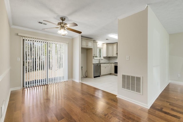 unfurnished living room featuring ornamental molding, visible vents, and light wood-type flooring