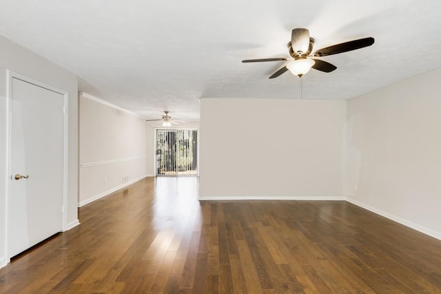 spare room featuring baseboards, wood finished floors, and a ceiling fan