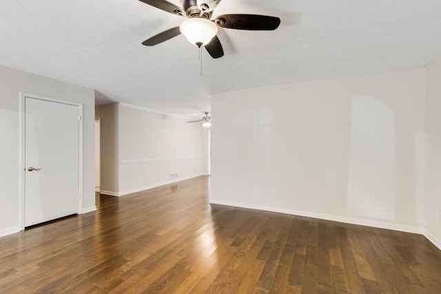 spare room with baseboards and wood finished floors