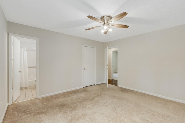 empty room with baseboards, light carpet, and ceiling fan