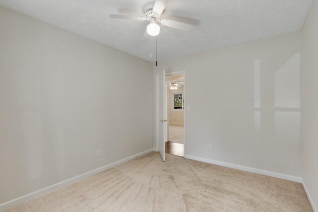 carpeted spare room with baseboards and ceiling fan