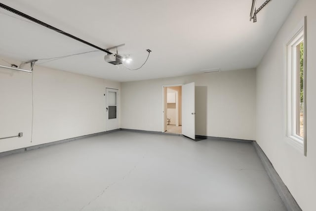 garage featuring a garage door opener and baseboards