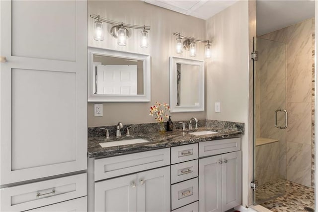 bathroom with a stall shower, a sink, and double vanity