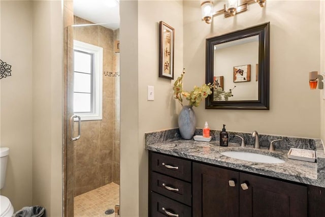 full bathroom with a stall shower, vanity, and toilet