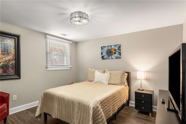 bedroom featuring visible vents, baseboards, and wood finished floors