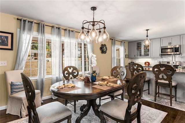 dining space featuring dark wood-style floors and baseboards