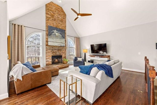 living room featuring ceiling fan, a fireplace, dark hardwood / wood-style floors, and high vaulted ceiling