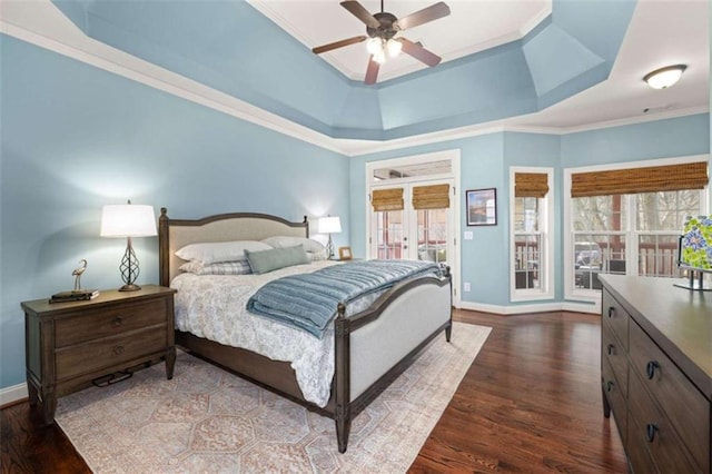 bedroom with a tray ceiling, ornamental molding, dark hardwood / wood-style floors, and ceiling fan