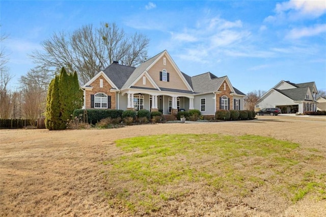 craftsman-style home with covered porch and a front lawn