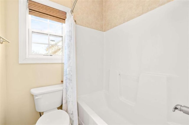 bathroom with shower / bath combination with curtain and toilet