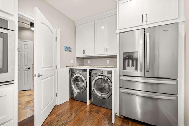 washroom with dark wood-type flooring, independent washer and dryer, and a barn door