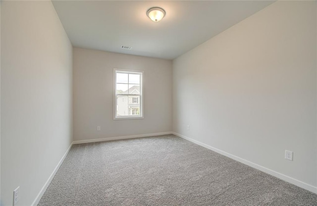 empty room with baseboards, visible vents, and carpet flooring