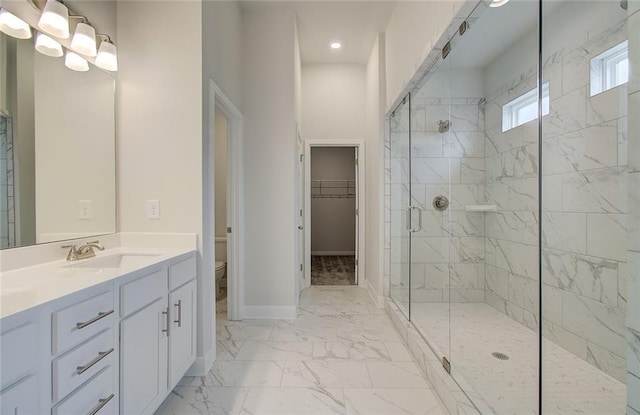 full bathroom with marble finish floor, toilet, a stall shower, vanity, and baseboards