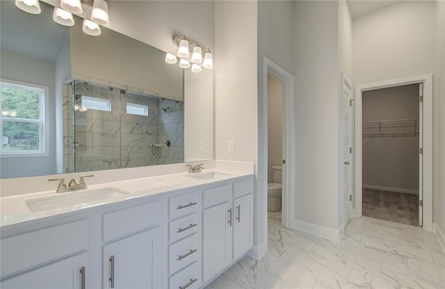 full bathroom with toilet, marble finish floor, a shower stall, and a sink